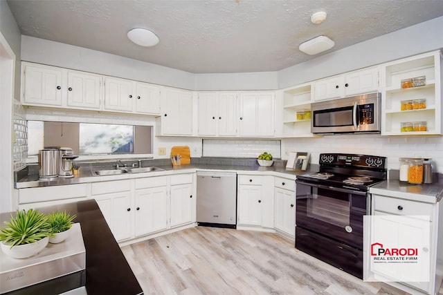 kitchen with stainless steel appliances, decorative backsplash, light wood-type flooring, white cabinets, and sink