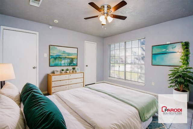 tiled bedroom featuring ceiling fan