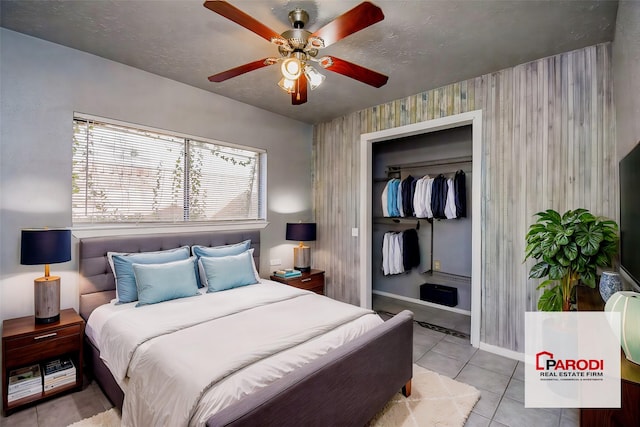 bedroom with ceiling fan, light tile patterned floors, and a closet