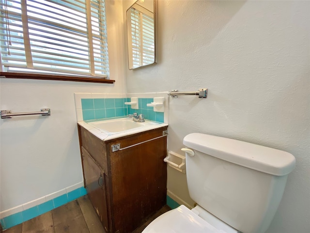 bathroom with vanity, hardwood / wood-style floors, backsplash, and toilet