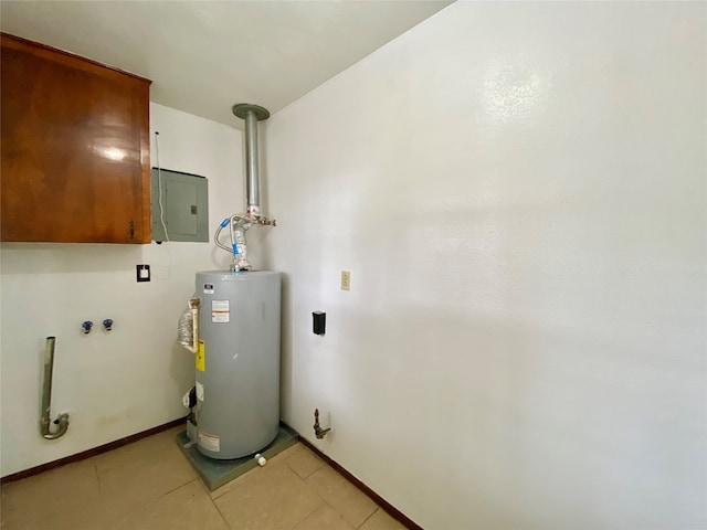 clothes washing area with electric panel, water heater, light tile patterned floors, and cabinets