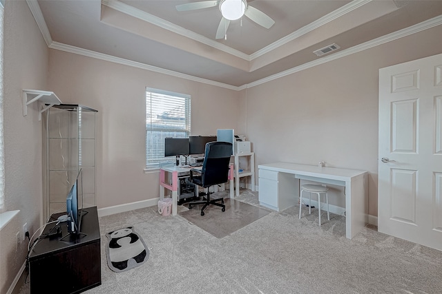 carpeted office featuring a tray ceiling, ceiling fan, and ornamental molding