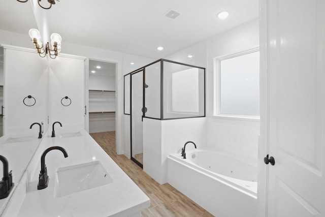 bathroom with plus walk in shower, wood-type flooring, and vanity