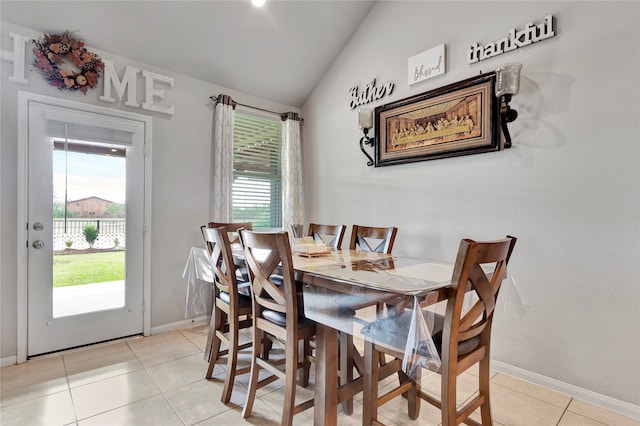 dining space with vaulted ceiling, a wealth of natural light, and light tile patterned flooring