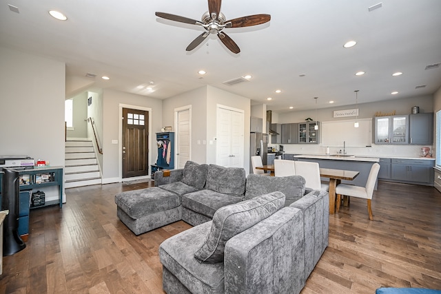 living room with hardwood / wood-style flooring, ceiling fan, and sink