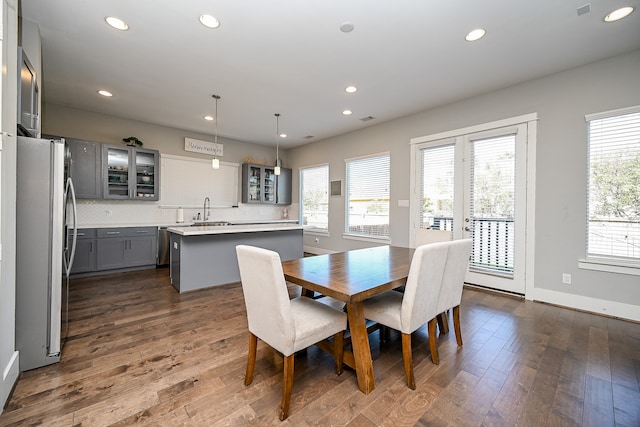 dining space with a wealth of natural light, dark wood-type flooring, and sink