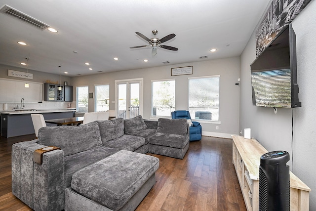 living room with dark hardwood / wood-style floors, ceiling fan, and sink