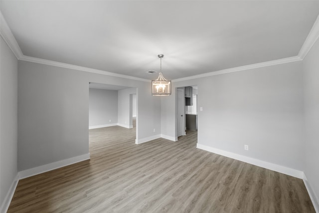 unfurnished room with a notable chandelier, light hardwood / wood-style floors, and ornamental molding