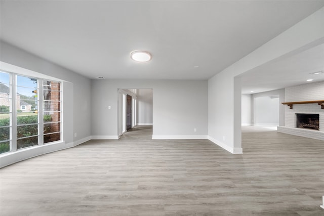 unfurnished living room featuring a fireplace and light hardwood / wood-style floors