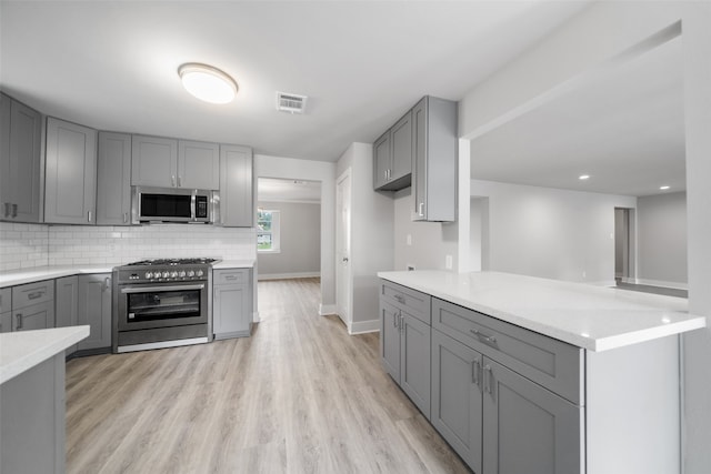 kitchen with gray cabinets and appliances with stainless steel finishes