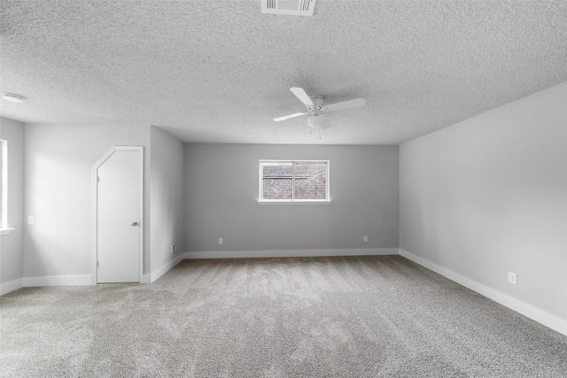 unfurnished room featuring ceiling fan, light colored carpet, and a textured ceiling