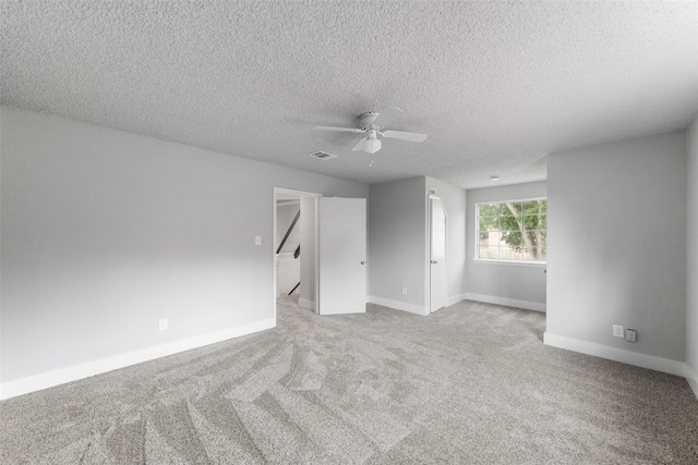 carpeted spare room with a textured ceiling and ceiling fan