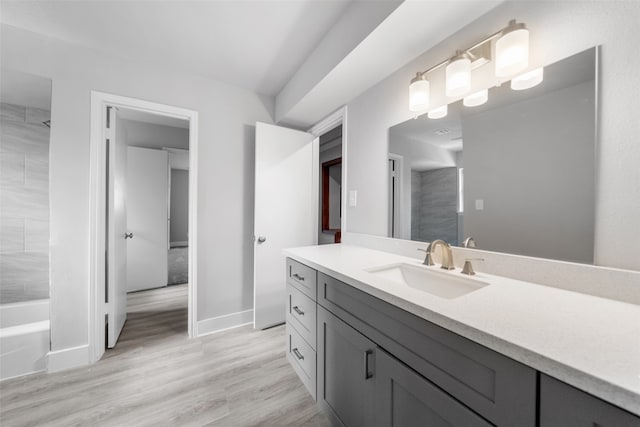 bathroom with hardwood / wood-style floors, vanity, and tub / shower combination