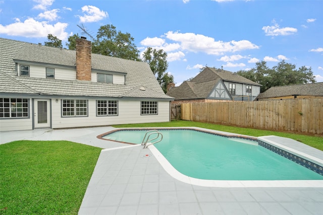 view of pool with a lawn and a patio