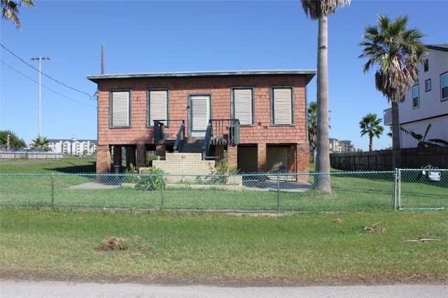 view of front of property featuring brick siding, a front yard, and fence private yard