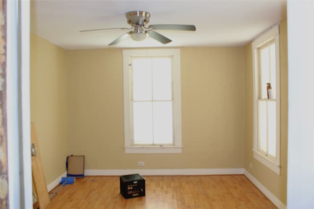 unfurnished room featuring a ceiling fan, baseboards, and light wood finished floors