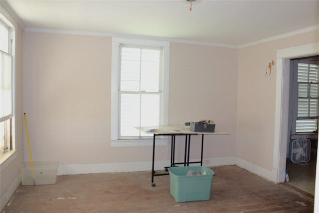 unfurnished room featuring ornamental molding, wood finished floors, and baseboards