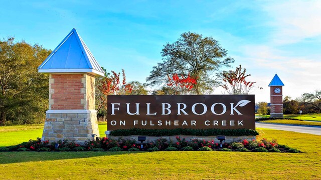 community sign featuring a lawn