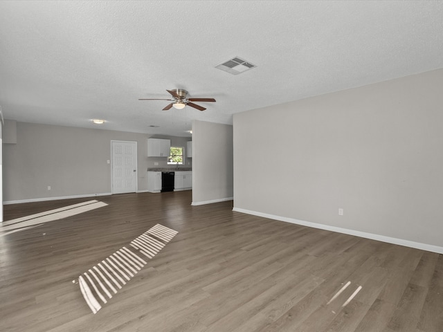 unfurnished living room with a textured ceiling, hardwood / wood-style flooring, and ceiling fan