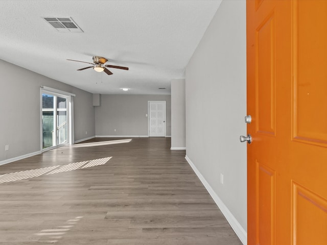 interior space featuring ceiling fan, hardwood / wood-style floors, and a textured ceiling