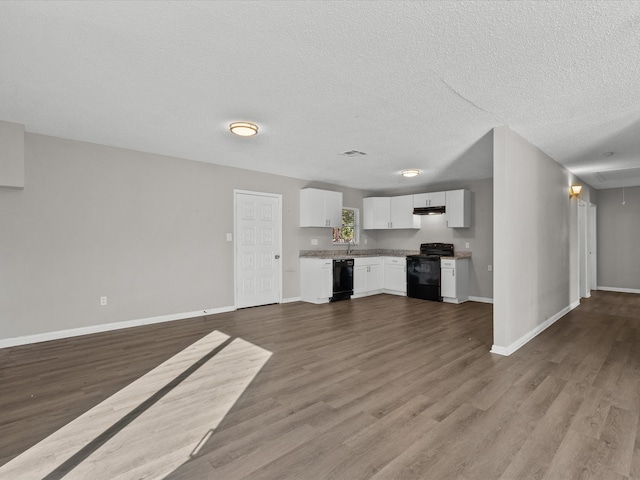 unfurnished living room with hardwood / wood-style floors, sink, and a textured ceiling