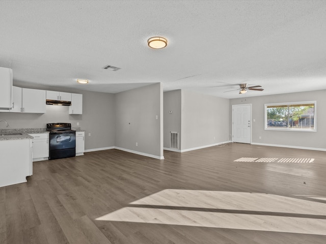 interior space with black electric range, hardwood / wood-style floors, white cabinets, and sink