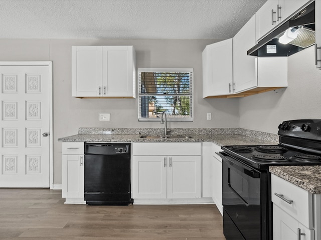 kitchen with black appliances, white cabinets, wood-type flooring, and sink