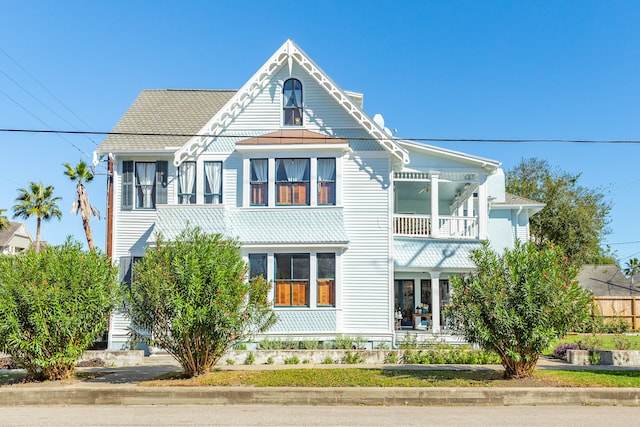 view of front of home featuring a balcony and ceiling fan