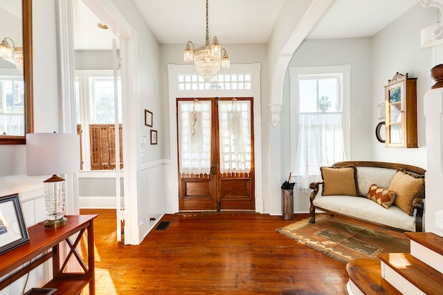 foyer entrance featuring hardwood / wood-style flooring and a notable chandelier