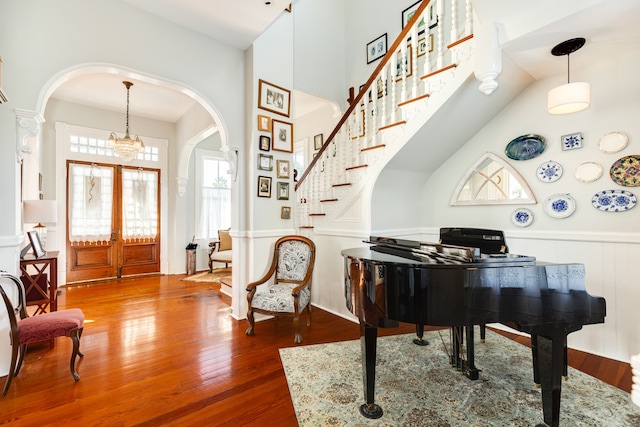 foyer entrance featuring hardwood / wood-style flooring, french doors, and an inviting chandelier