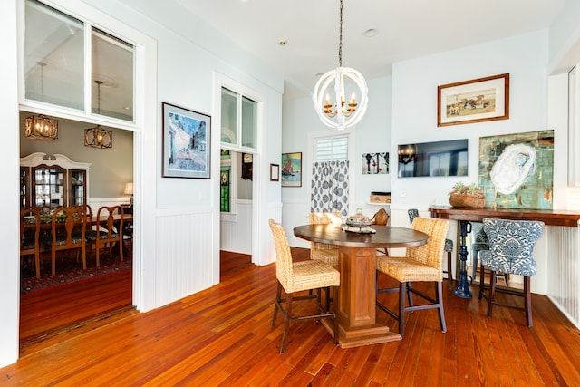 dining area featuring hardwood / wood-style floors and an inviting chandelier