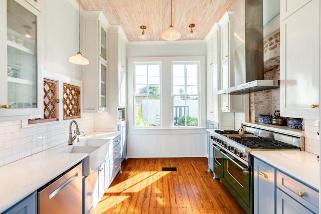 kitchen featuring pendant lighting, wooden ceiling, light hardwood / wood-style flooring, wall chimney exhaust hood, and stainless steel appliances