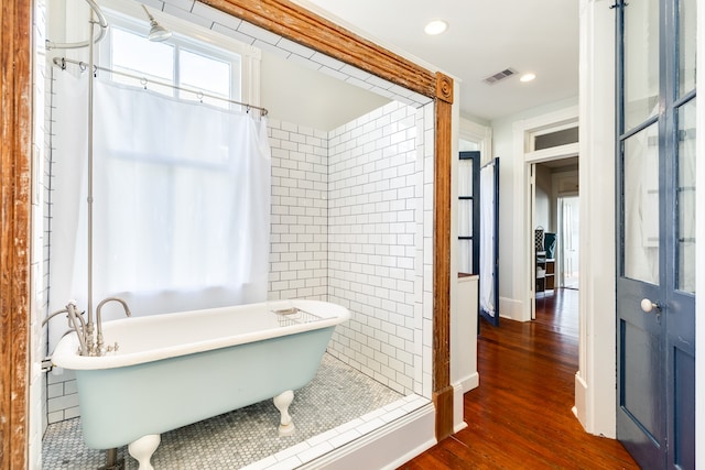 bathroom with hardwood / wood-style flooring, separate shower and tub, and tile walls