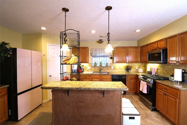 kitchen with pendant lighting, a kitchen island, sink, and appliances with stainless steel finishes