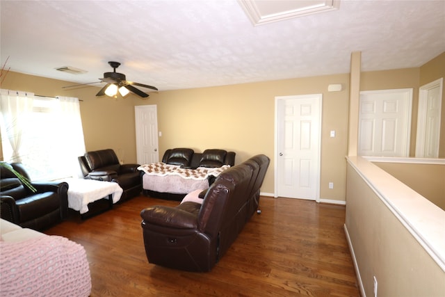 living room featuring ceiling fan and dark wood-type flooring