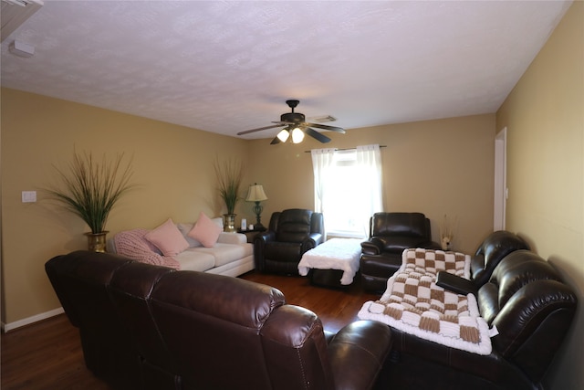 living room with a textured ceiling, ceiling fan, and dark hardwood / wood-style floors