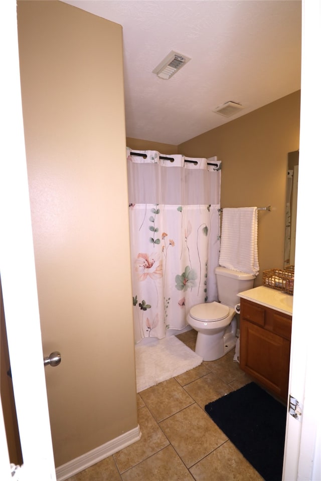 bathroom with tile patterned flooring, vanity, and toilet