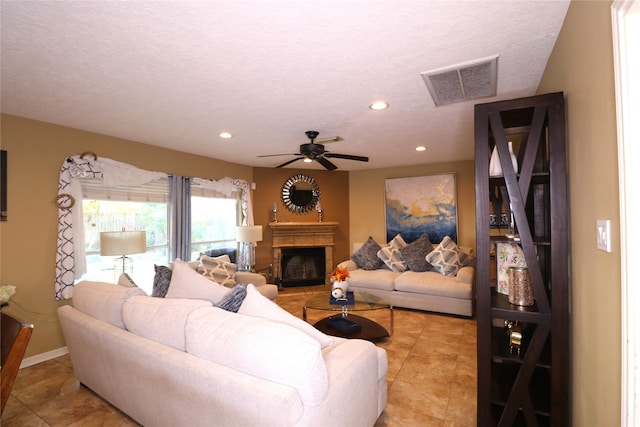 living room with light tile patterned floors, a textured ceiling, and ceiling fan