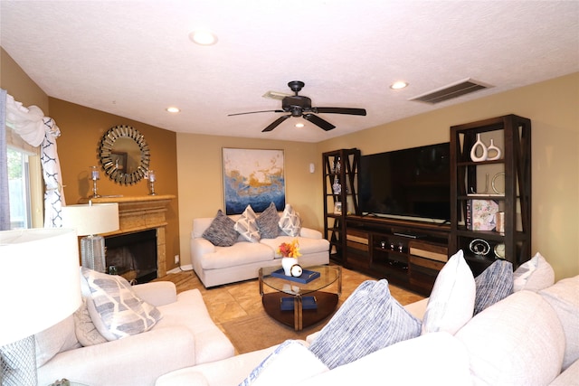 tiled living room featuring ceiling fan and a textured ceiling