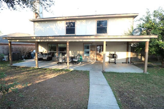 rear view of house with a yard, a patio area, and outdoor lounge area