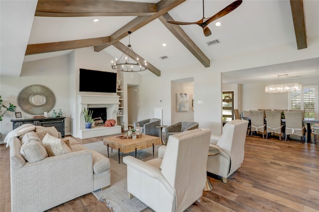 living room with vaulted ceiling with beams, hardwood / wood-style floors, and ceiling fan with notable chandelier