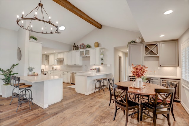 kitchen with kitchen peninsula, light hardwood / wood-style floors, and a breakfast bar area