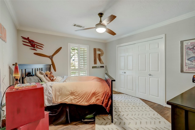 bedroom featuring a closet, ceiling fan, ornamental molding, and hardwood / wood-style flooring