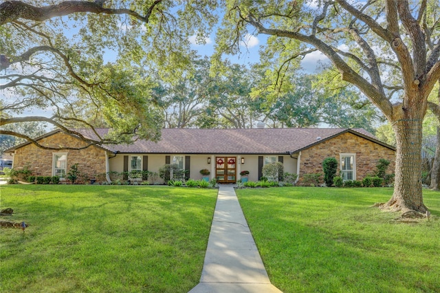 ranch-style home featuring a front yard and french doors