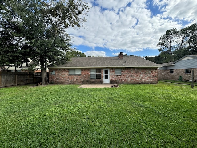 back of property with a lawn and a patio