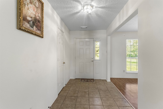 doorway to outside with hardwood / wood-style floors and a textured ceiling