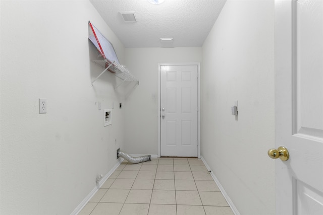 laundry area with electric dryer hookup, light tile patterned floors, a textured ceiling, and hookup for a washing machine