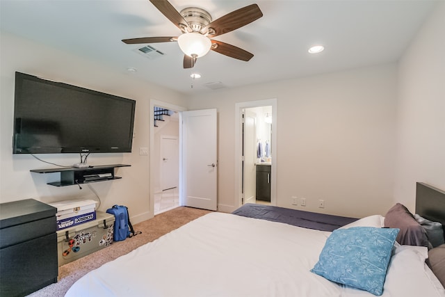 bedroom with ensuite bath, light carpet, and ceiling fan