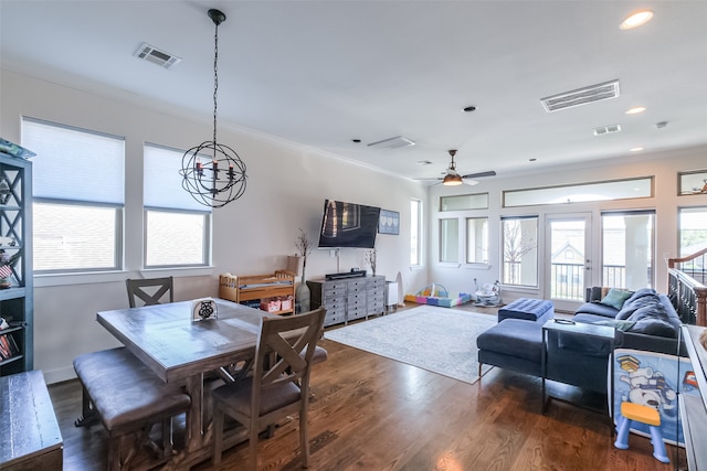 dining space featuring ceiling fan, ornamental molding, and dark wood-type flooring