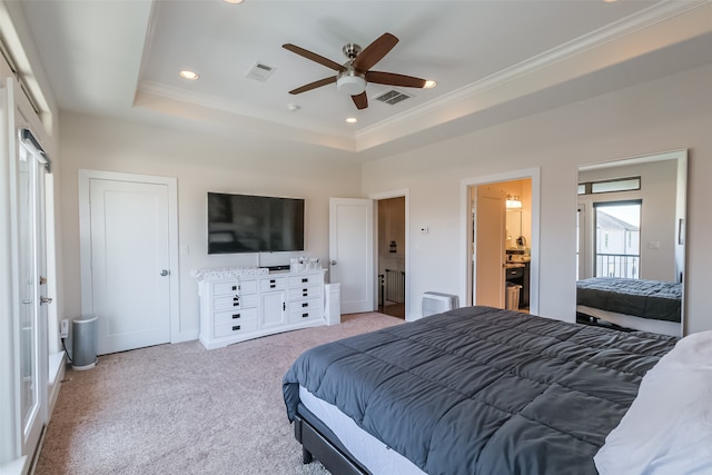 carpeted bedroom with ceiling fan, ensuite bath, ornamental molding, and a tray ceiling